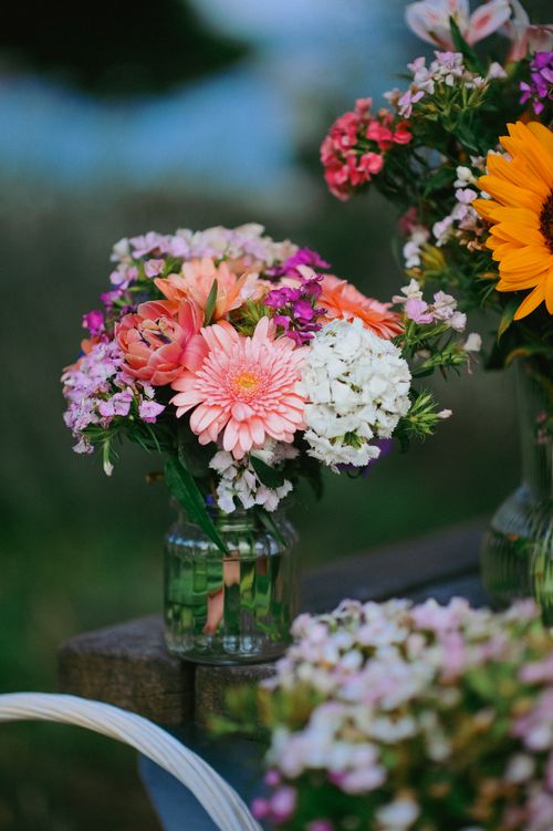 Free A colorful bouquet of mixed flowers in a glass jar captured outdoors, showcasing nature's beauty. Stock Photo