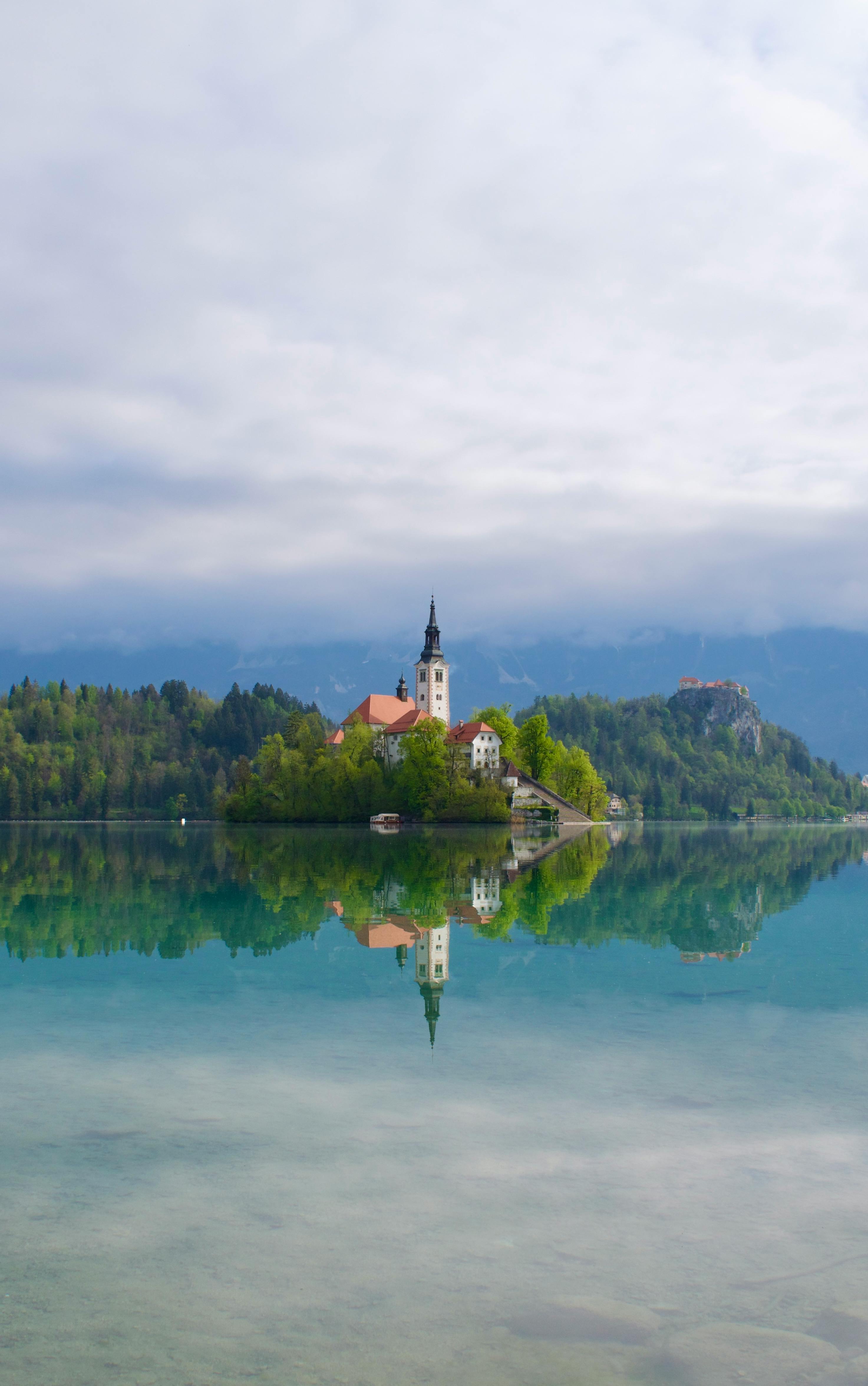 Serene reflection of Bled Island and church on Lake Bled, Slovenia.