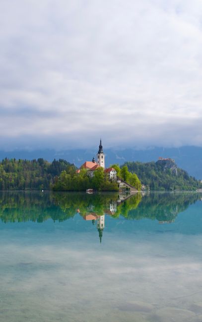 Serene reflection of Bled Island and church on Lake Bled, Slovenia.