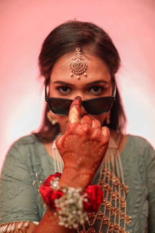Woman in Traditional Clothing and Jewelry with Henna Tattoos on Her Hand 