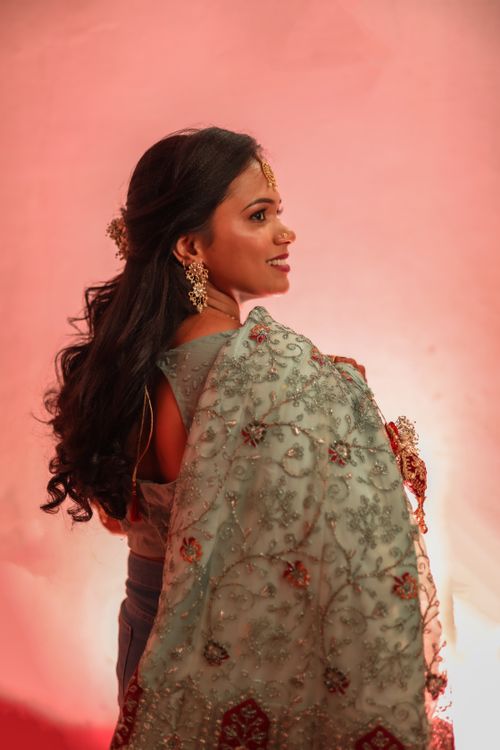Free A woman in traditional attire posing against a soft pink background. Stock Photo