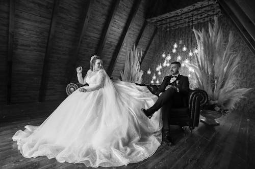 Free Wedding Couple Sitting on a Sofa in Black and White Stock Photo