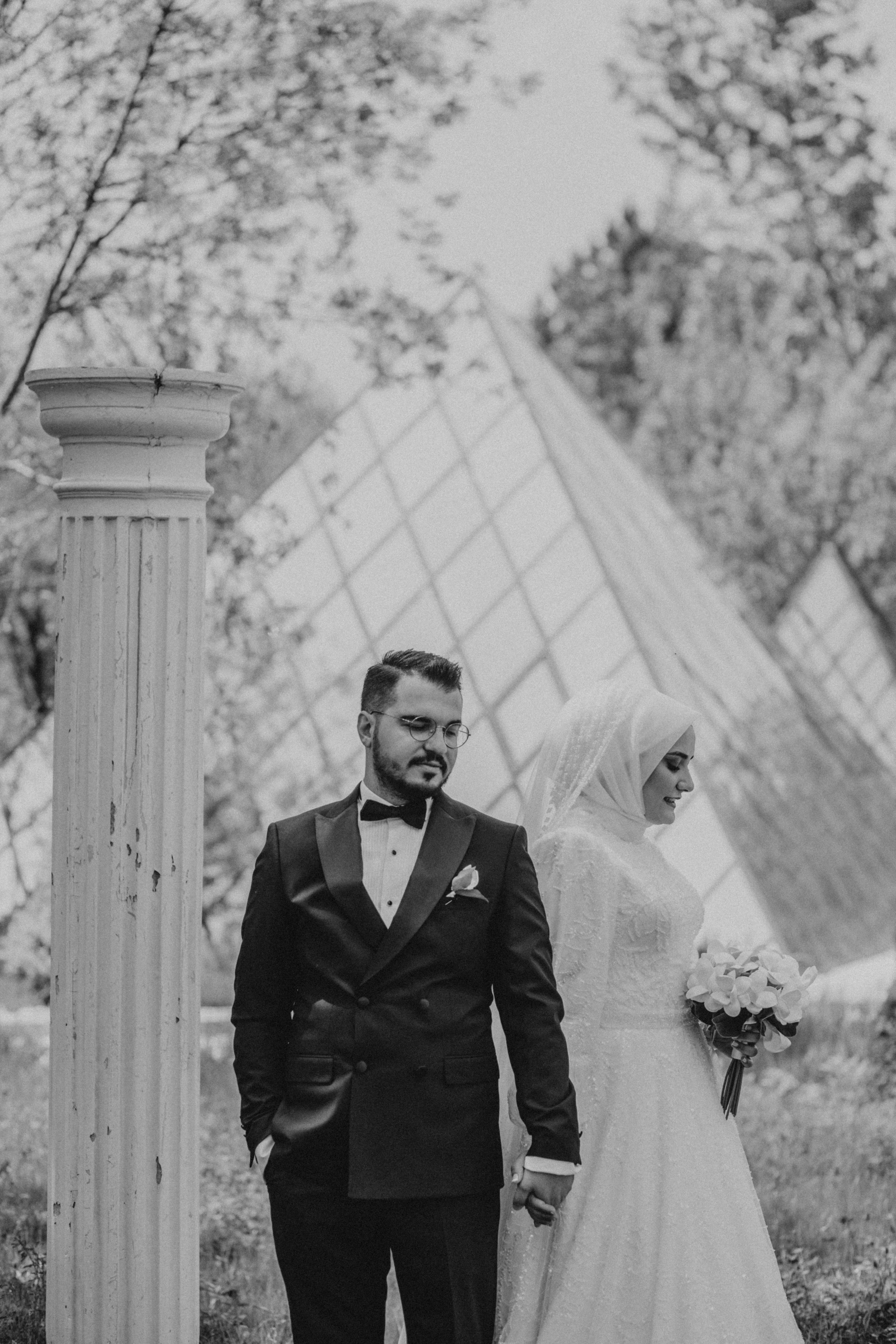 A timeless black and white portrait of a bride and groom standing outdoors, showcasing romance and elegance.