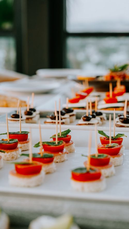 Free Gourmet appetizers featuring tomatoes, olives, and fresh herbs on a festive platter. Stock Photo