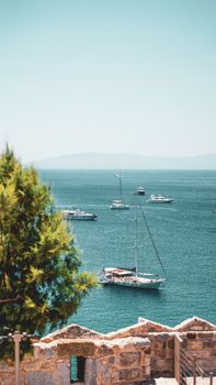 Beautiful harbor with sailboats and yachts on a calm sea under a clear sky.
