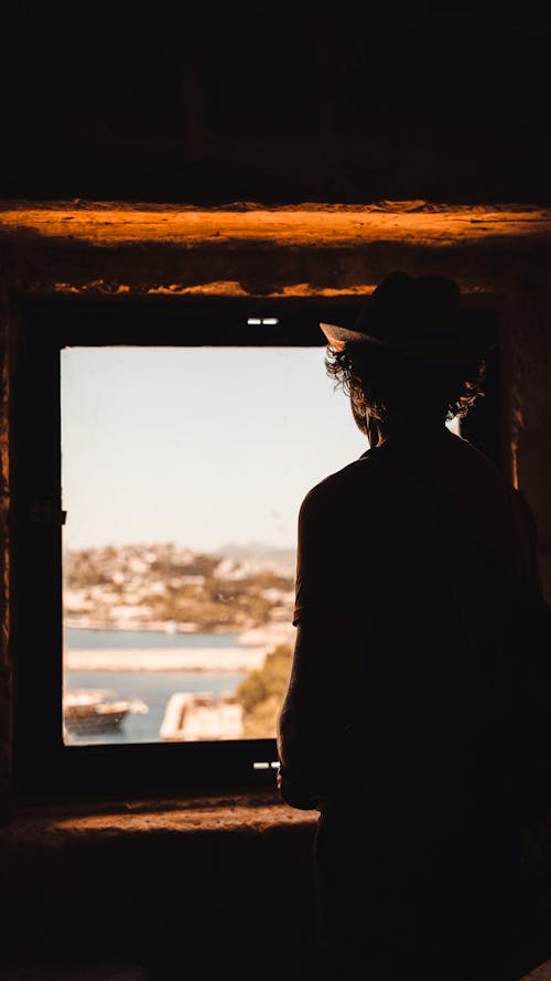 Silhouette of a Man Looking Out the Window
