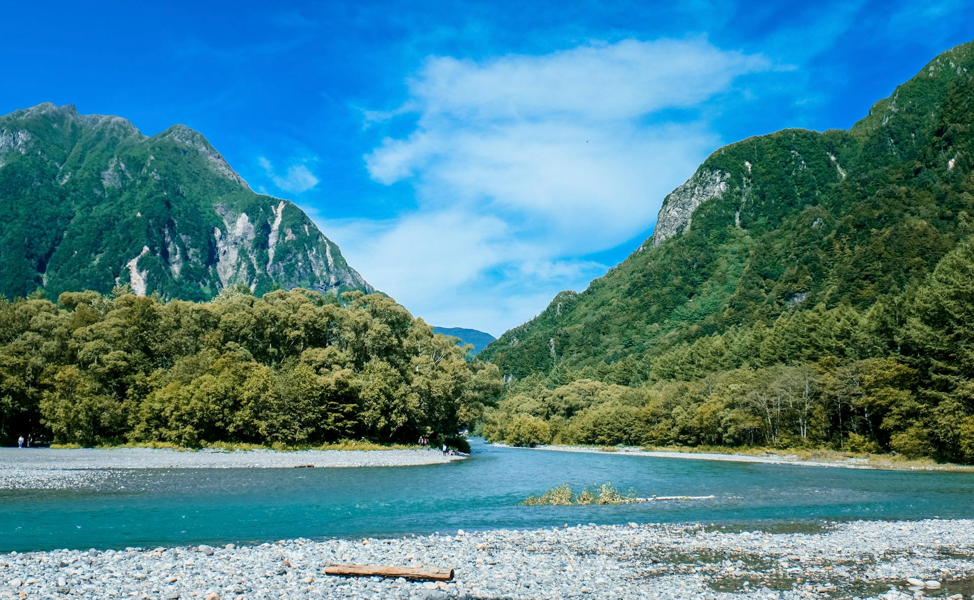 Scenic view of mountains, river, and lush forest in Nagano, Japan during summer.