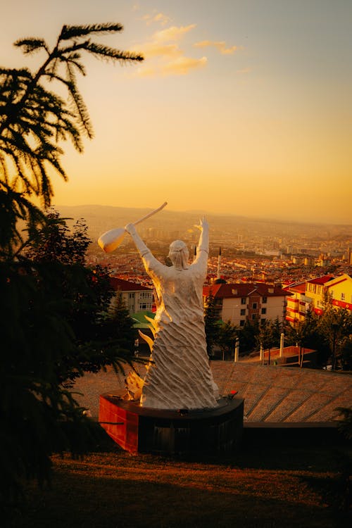 A Statue on Top of a Hill Overlooking the City 
