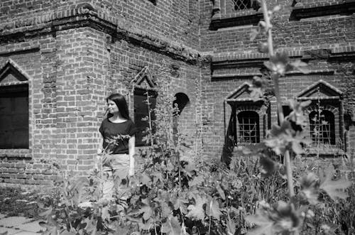 Young Woman Standing in front of an Old Brick Building 