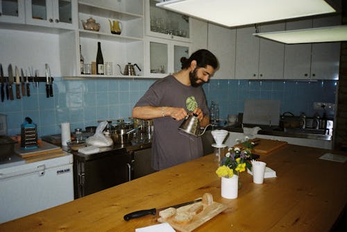Man Preparing Coffee in a Kitchen
