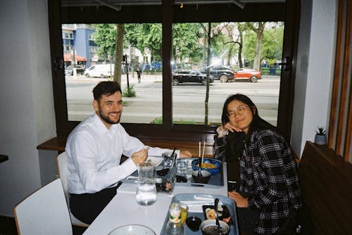 Young Man and Woman Eating at the Restaurant 