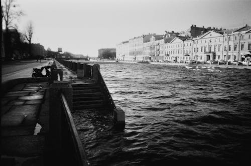 Black and White Picutre of a River and Waterfront Houses in City 