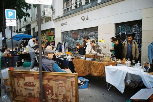 Free Explore a bustling urban flea market with various stalls, antique goods, and engaged shoppers. Stock Photo