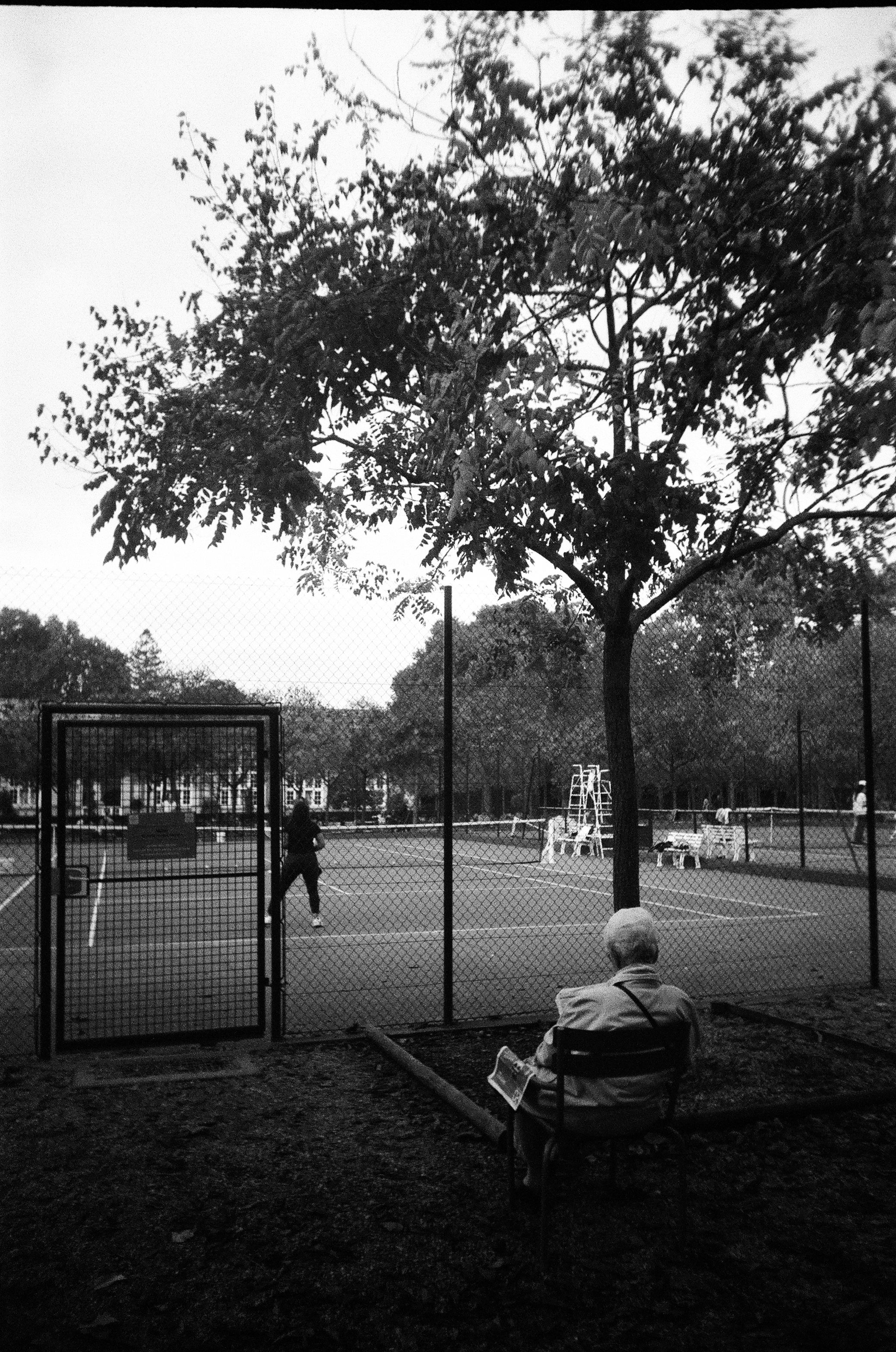Man Sitting near Tennis Court · Free Stock Photo