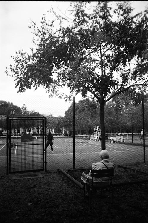 Man Sitting near Tennis Court