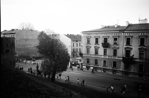 Free Black and white street scene capturing a historic European urban street with buildings and people. Stock Photo