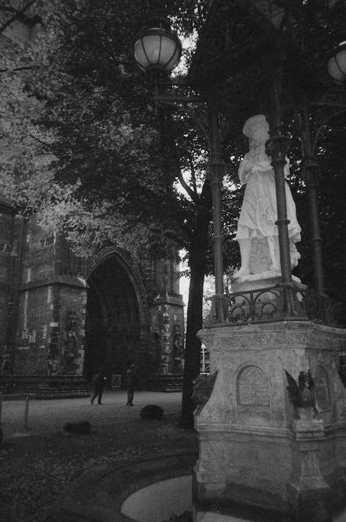 Sculpture under Trees near Church in Black and White