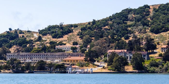 Panoramic view of Angel Island's historic buildings along the Californian coast under a clear sky.