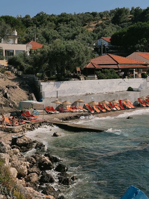 Free Charming Mediterranean beach scene with vibrant umbrellas and serene waters. Stock Photo