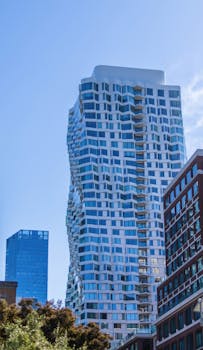 A stunning example of modern architecture with a distinctive curved design in a city setting.