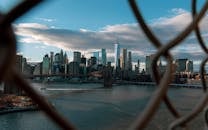 透过栅栏，可以欣赏到纽约市令人惊叹的天际线，其中摩天大楼和布鲁克林大桥尽收眼底