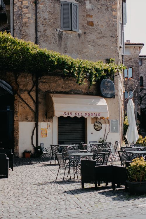 Free A sunlit cobblestone square with an inviting outdoor cafe in a charming European town. Stock Photo