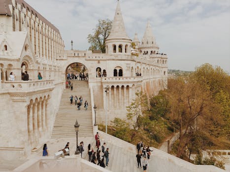 Tourists exploring the historic Fisherman's Bastion in Budapest, Hungary on a beautiful day.