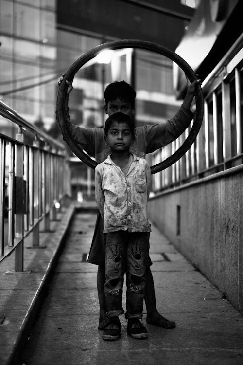 Boys with Large Ring Posing on Pavement in City