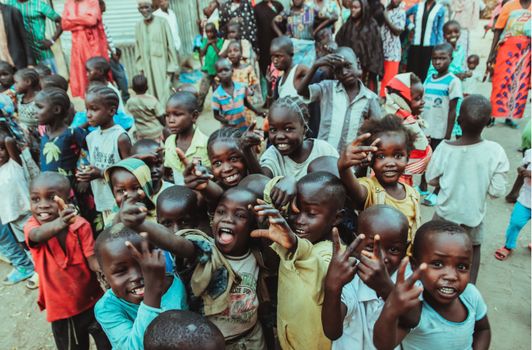A lively group of African children posing playfully outdoors, exuding joy and camaraderie.