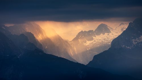 Free Sunset illuminates the majestic Alpine mountains under dramatic skies. Stock Photo