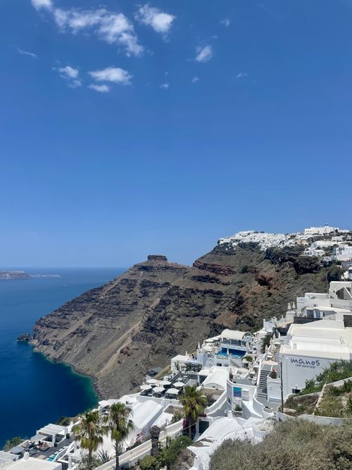 Free Stunning view of Fira's white architecture on Santorini's rugged coastline. Stock Photo