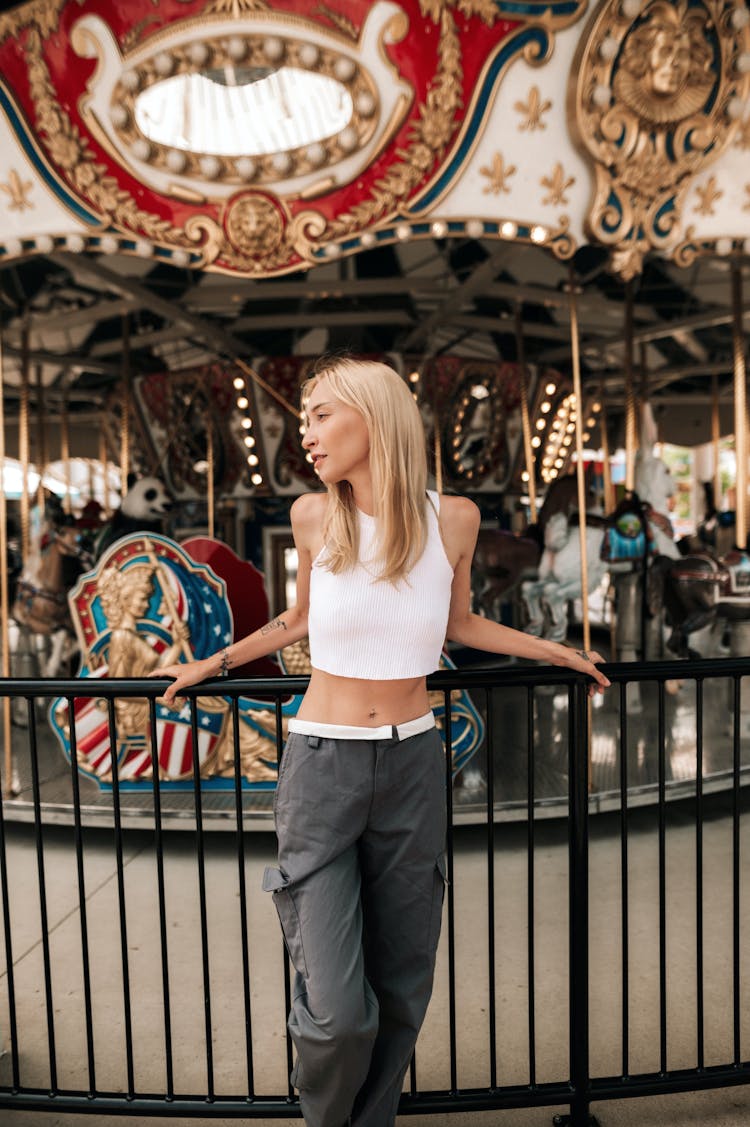 Blonde Woman Posing By Carousel