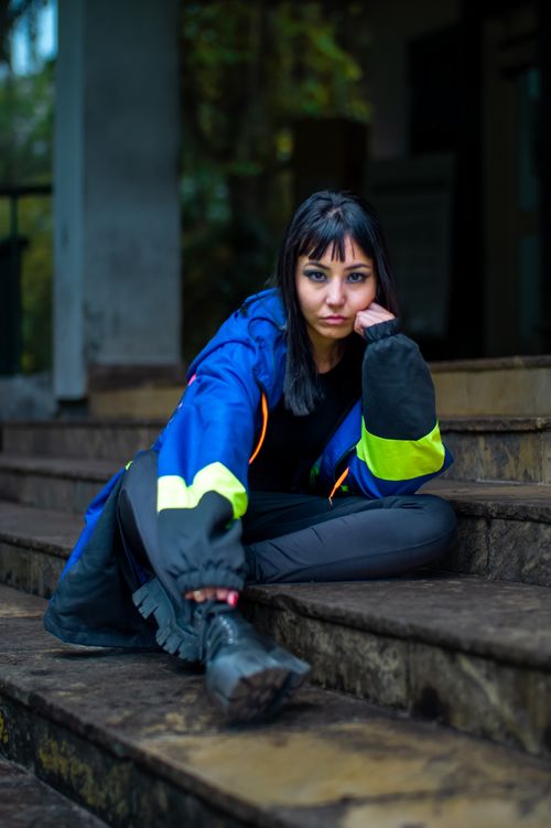 Free A young woman in a blue jacket poses confidently on stairs in São Paulo, Brazil. Stock Photo