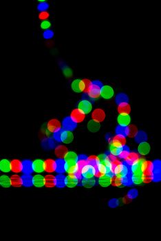 Vivid bokeh of colorful lights against a dark backdrop, creating an abstract visual effect.