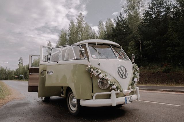 Combi Volkswagen vintage fleuri garé sur une route de campagne
