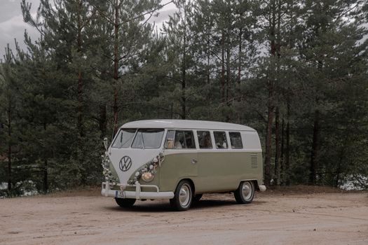 A vintage Volkswagen van parked amidst an evergreen forest, evoking nostalgia and adventure.