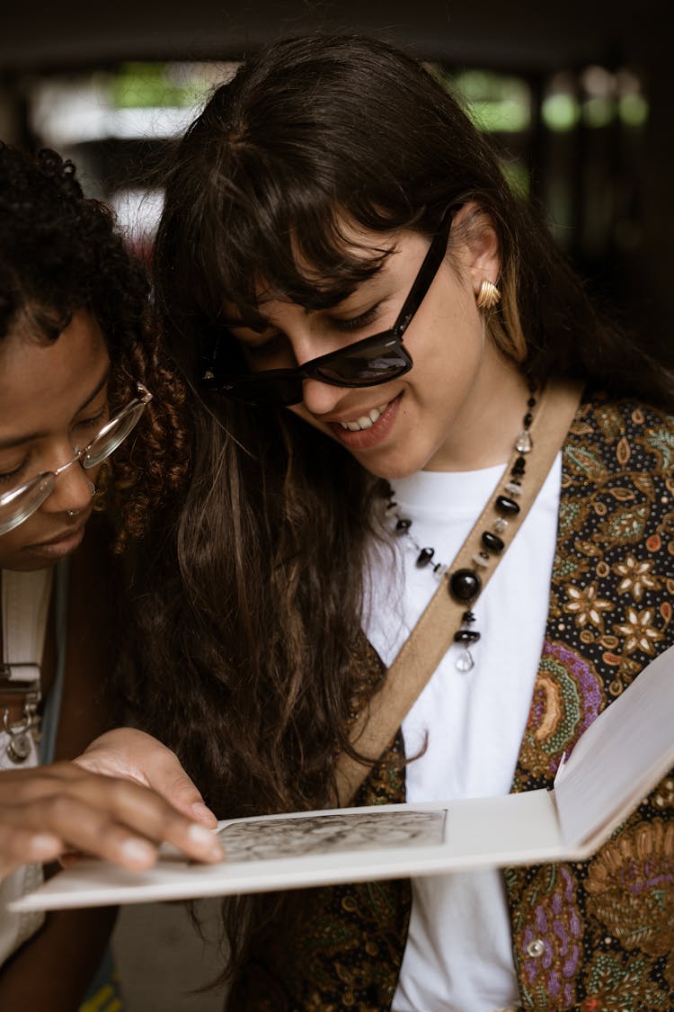 Women Looking At Image In Book 