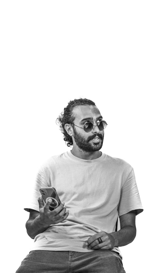 Black and White Photo of a Bearded Man in Sunglasses Holding a Smart Phone