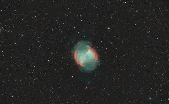 Vibrant image of the Dumbbell Nebula amidst starry cosmos, showcasing celestial beauty.