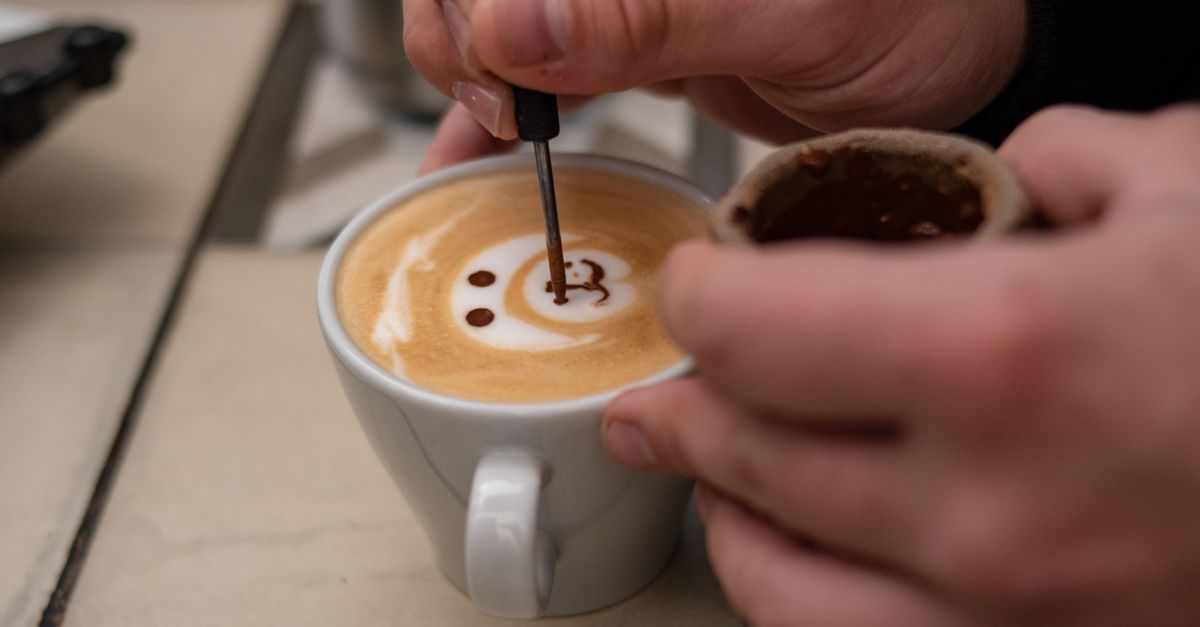A barista pouring latte art