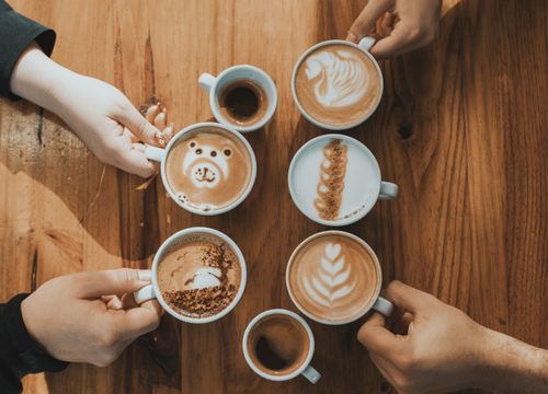 Free Various artistic lattes arranged on a wooden table, captured from above. Stock Photo
