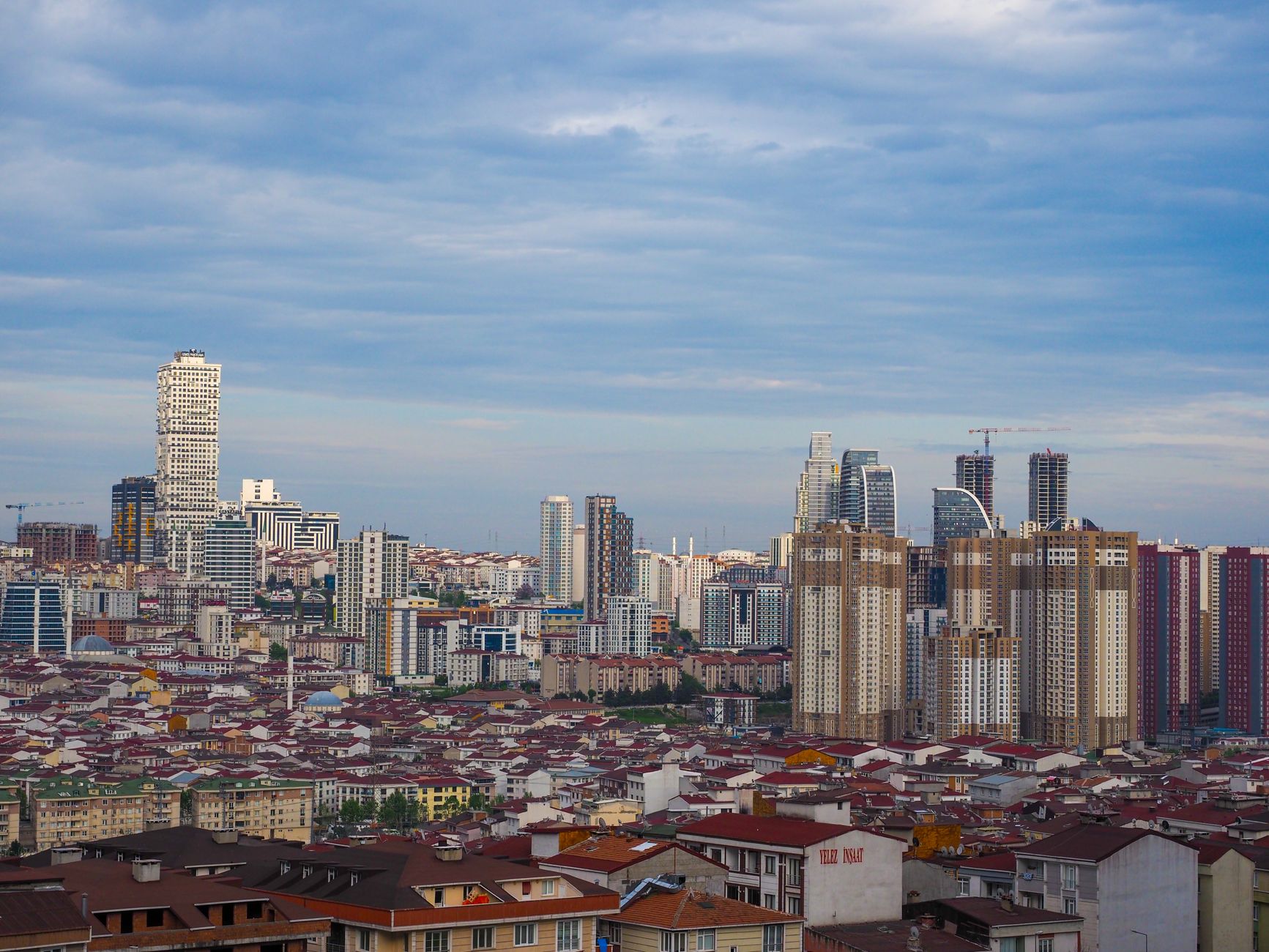 Türkiye'deki kentleşme oranlarını, modern şehir yapılarını ve kentsel gelişimi temsil eden panoramik bir şehir manzarası ve veri grafiği.