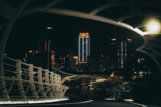 Illuminated Star-Of-Cianjhen Bridge in Kaohsiung with city skyline at night.
