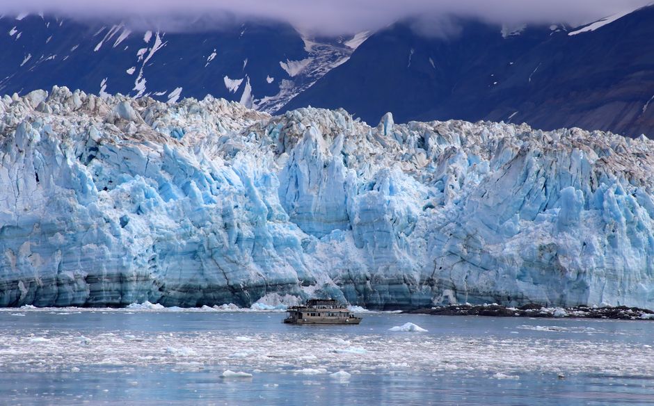 Helicopter Glacier Swim & Hike - Anchorage Area - A breathtaking view of Hubbard Glacier with a boat navigating the icy waters in Alaska.