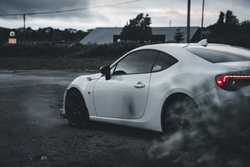Free A stylish white car parked in a suburban lot during twilight, showcasing modern automotive design. Stock Photo