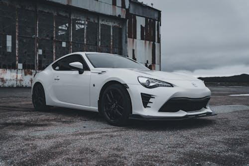 White Toyota 86 Sports Car Parked by an Abandoned Factory Warehouse