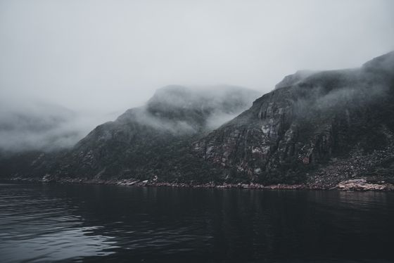 Misty mountains above a still lake, photo by Erik Mclean on Pexels