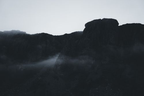 Free Dramatic mountain silhouette in misty fog during dawn. Stock Photo