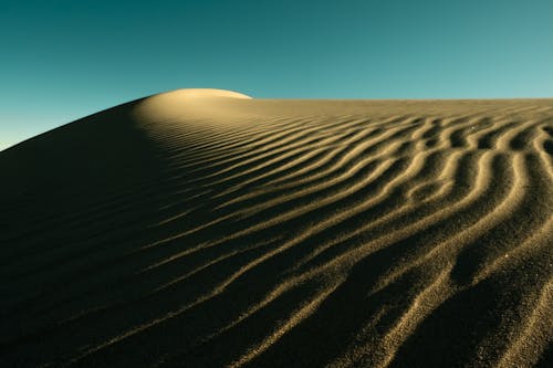 Sand Dune in Desert under Blue Sky