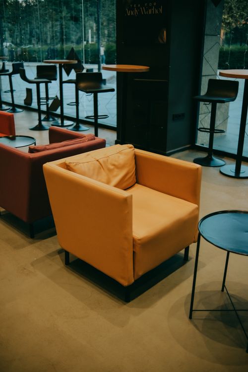 Free Modern café featuring stylish leather armchairs and minimalist décor for a relaxing atmosphere. Stock Photo